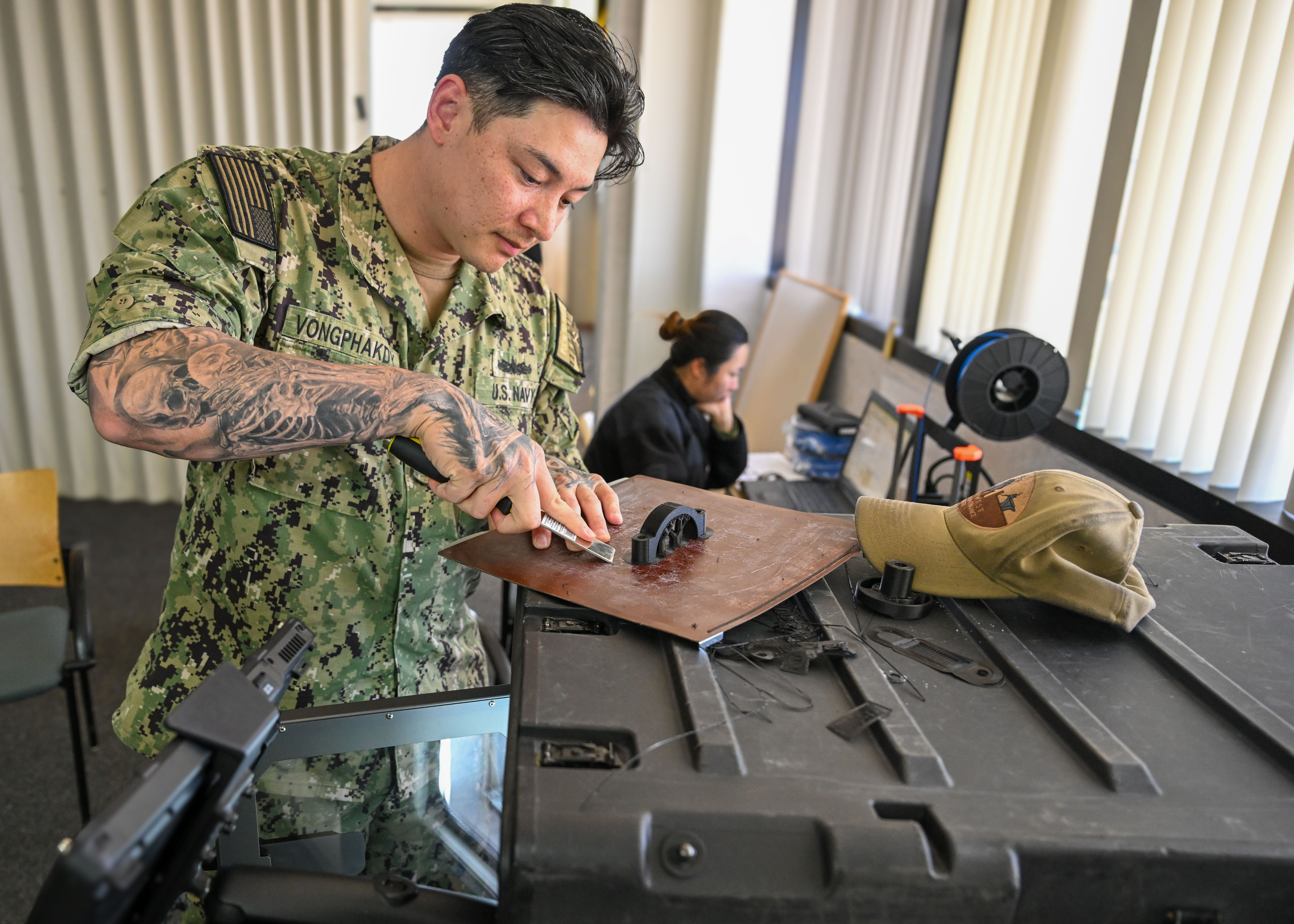 Petty Officer 1st Class Tyler Vongphakdy of Southwest Regional Maintenance Center scrapes 3D-printed part during Joint Exercise Southern California 2025 in Coronado, California, May 8, 2025 (U.S. Navy/Antonio Gonzalez)